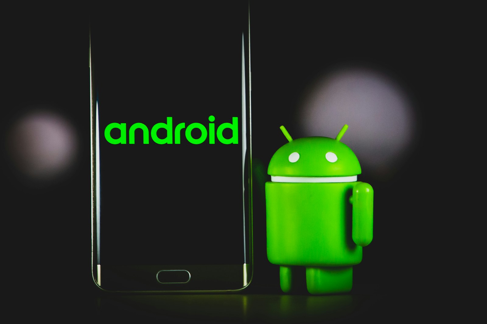 Ludzik reprezentujący Androida trzyma smartfon