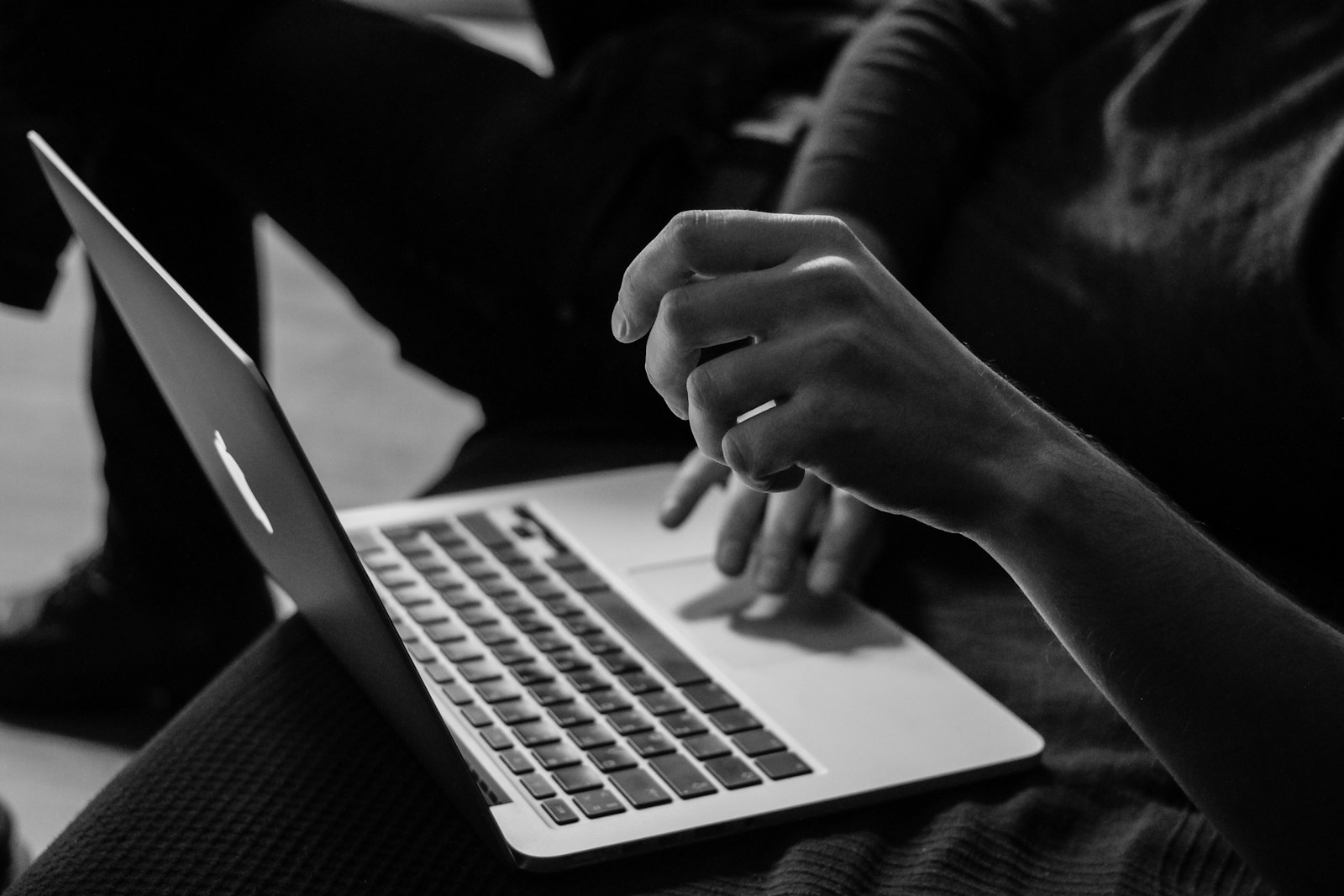 szaro-białe zdjęcie człowieka używającego laptopa